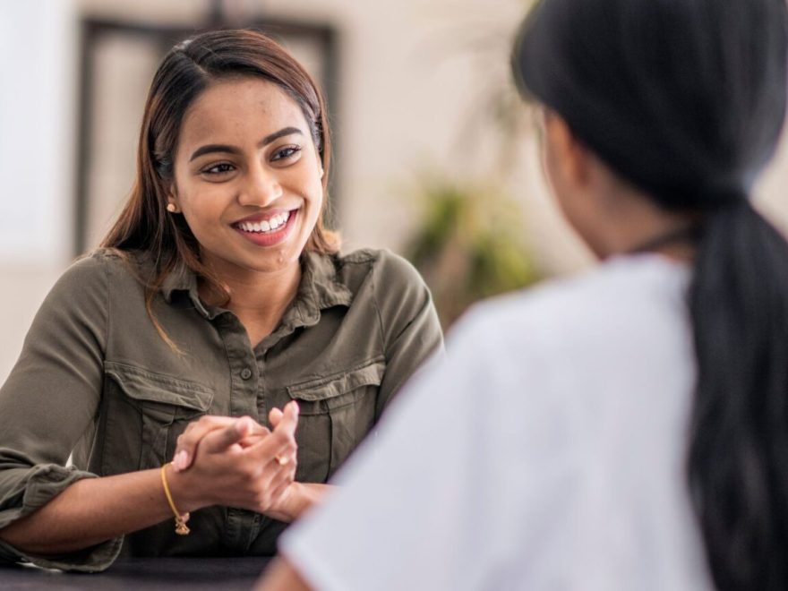 Two girls speaking with each other.