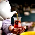 side-view-person-pouring-Sulaimani-Chai-