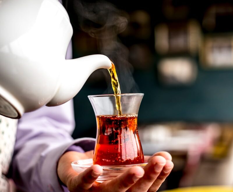 side-view-person-pouring-Sulaimani-Chai-