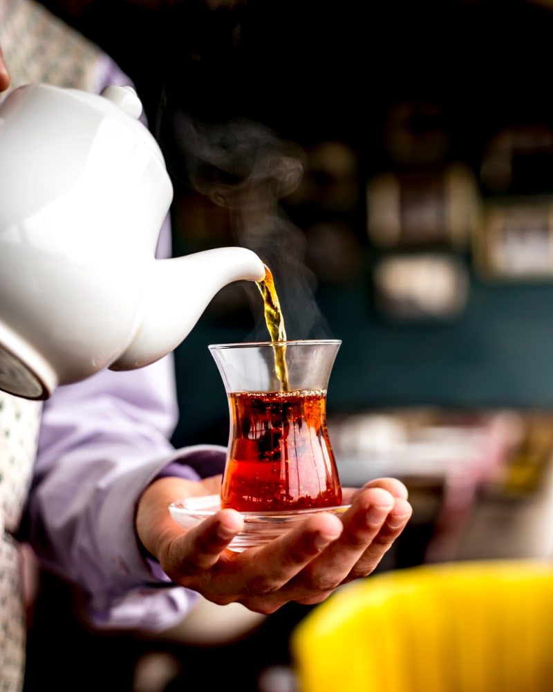 side-view-person-pouring-Sulaimani-Chai-