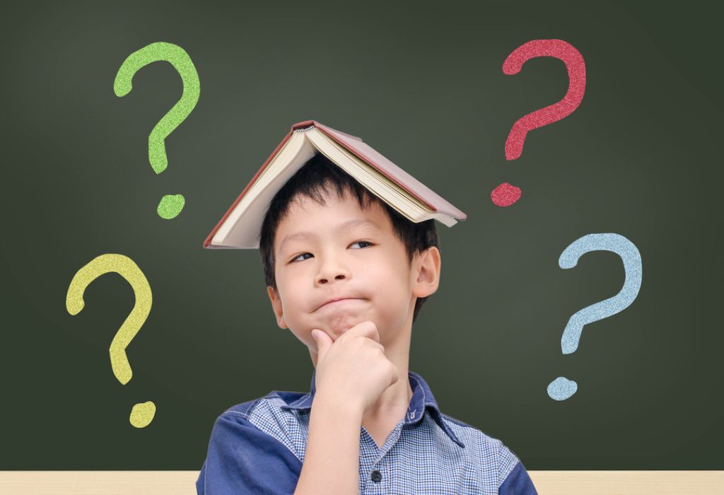 Asian boy with book on head thinking