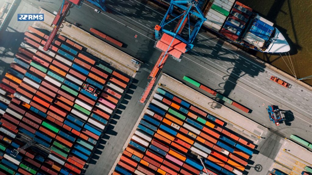 A panoramic view of Spare Parts in Barcelona bustling maritime scene, featuring ships docked at the port against a backdrop of vibrant city architecture and a clear blue sky.