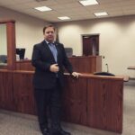 A Michigan Driver's License Restoration Attorney standing in his office.