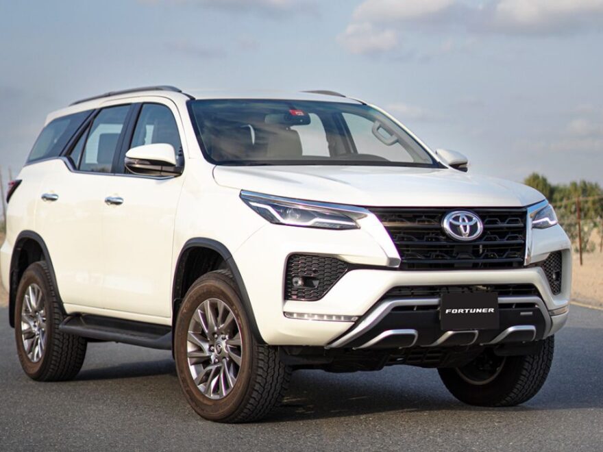 A Toyota Fortuner driving on a road, showcasing its sleek design and powerful performance.