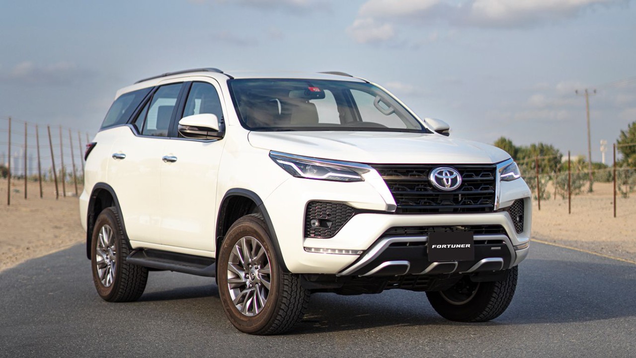 A Toyota Fortuner driving on a road, showcasing its sleek design and powerful performance.