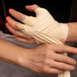 A man tie elastic compression bandages on his hand