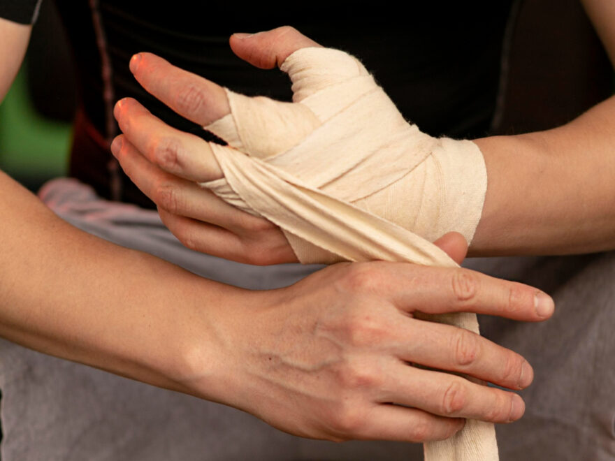 A man tie elastic compression bandages on his hand