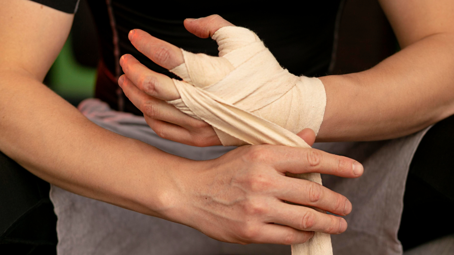 A man tie elastic compression bandages on his hand