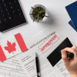 Close-up of a Canadian visa stamp in a passport alongside a Canadian flag, representing successful visa assistance by Canadian visa consultants in Hyderabad.