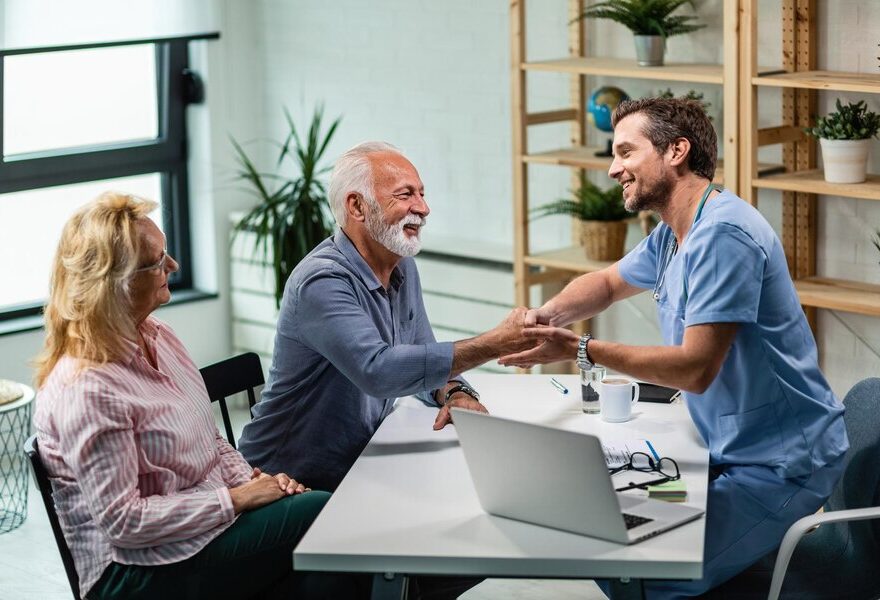 happy-male-doctor-shaking-hands-with-senior-man-who-came-medical-appointment-with-his-wife_