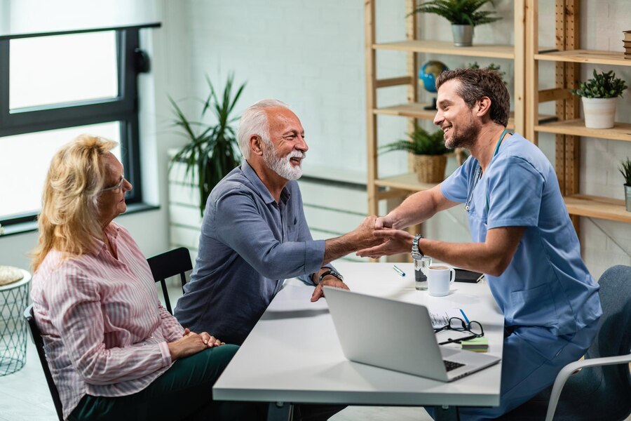 happy-male-doctor-shaking-hands-with-senior-man-who-came-medical-appointment-with-his-wife_