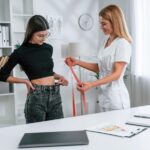 measuring-waist-young-woman-nutritionist-s-appointment-medical-care