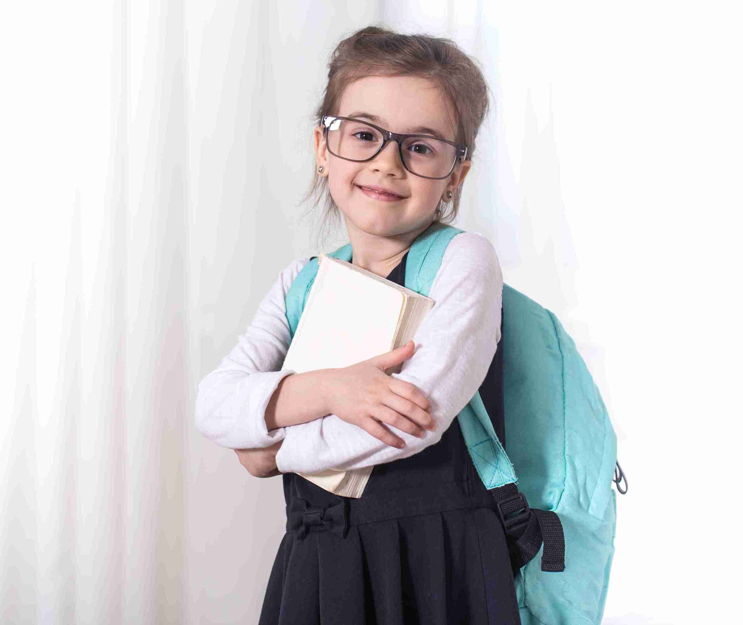 Girl-Grammar school student with a backpack and a book